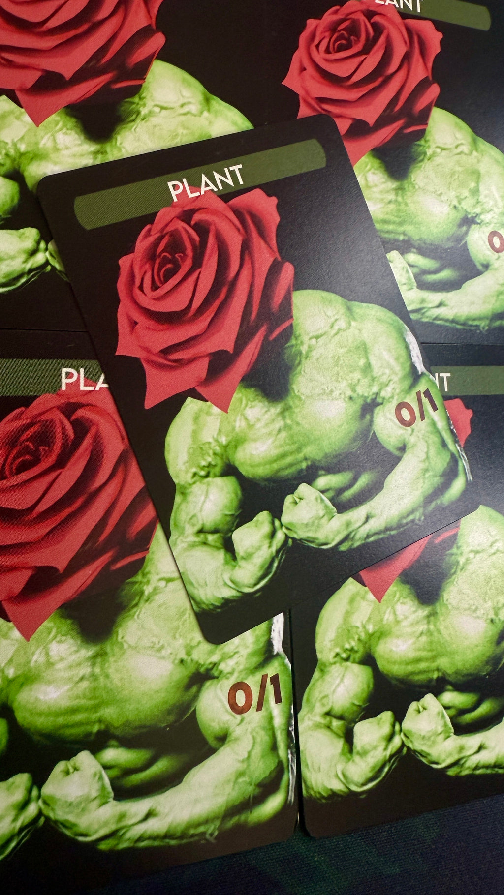 Two green superhero-like figures with red roses on a black background