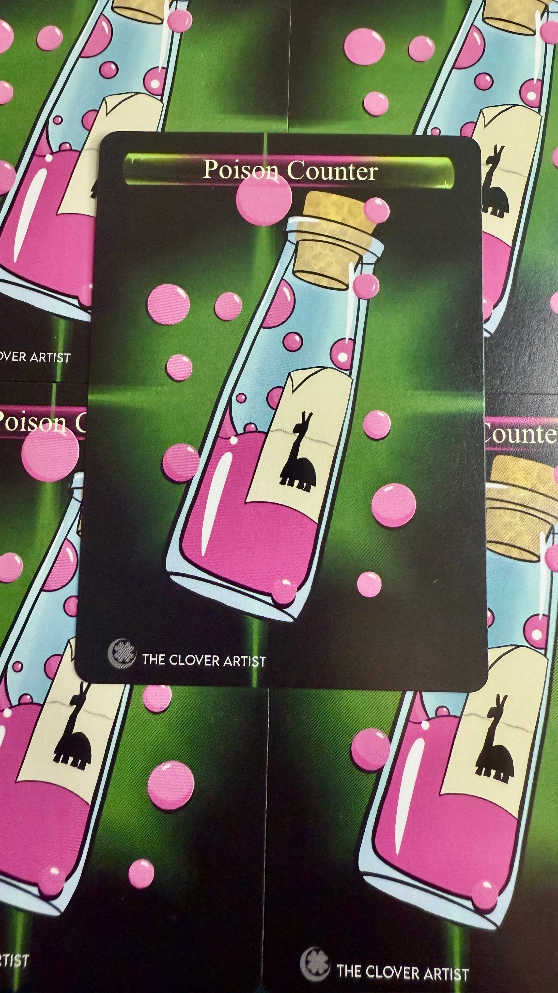 Card with a bottle of pink liquid and text 'Poison Counter' on a green background with pink polka dots.