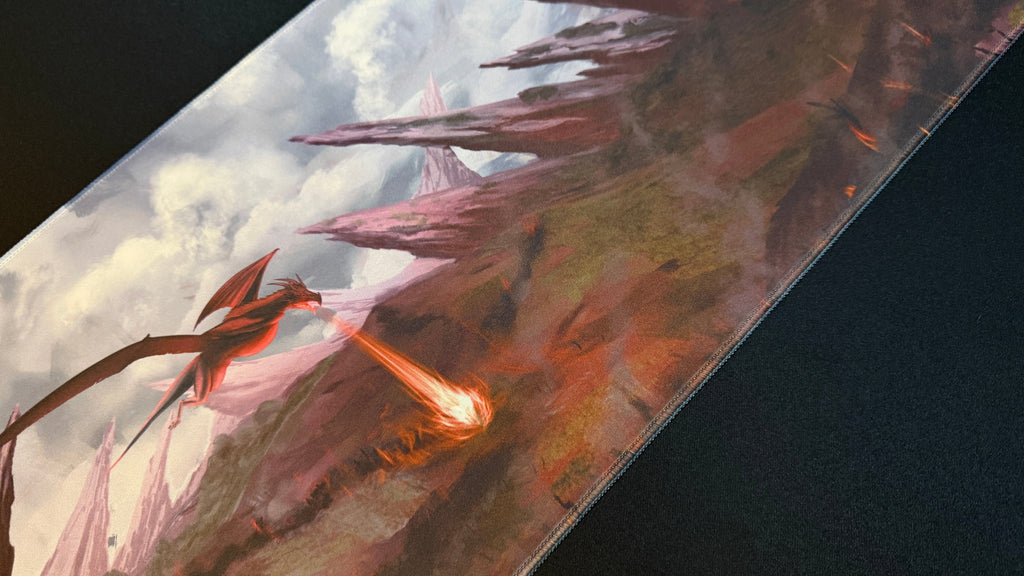 Red flying dragon battling over jagged landscape on a playmat