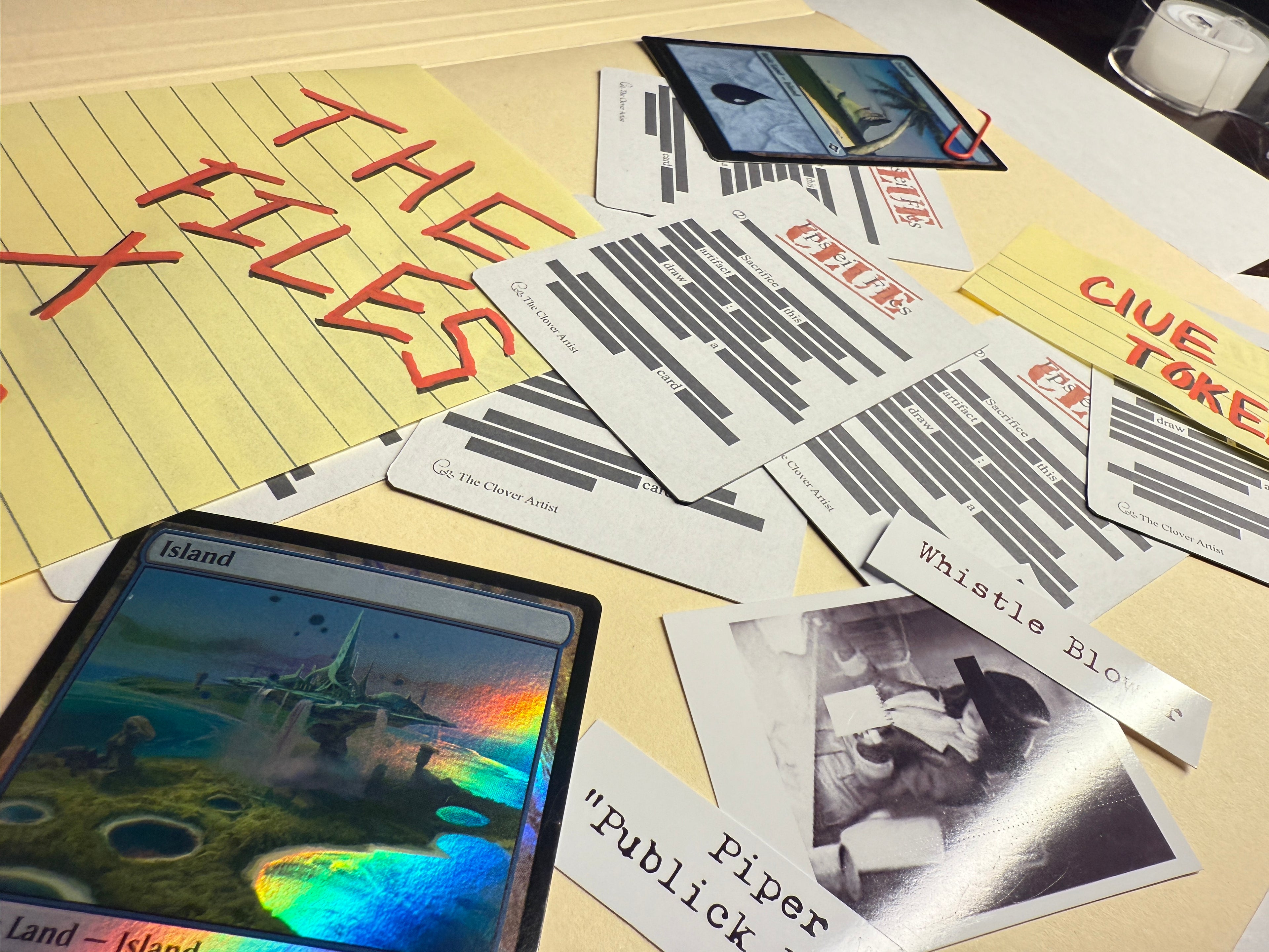 Scattered playing cards and a phone on a surface with text and images.