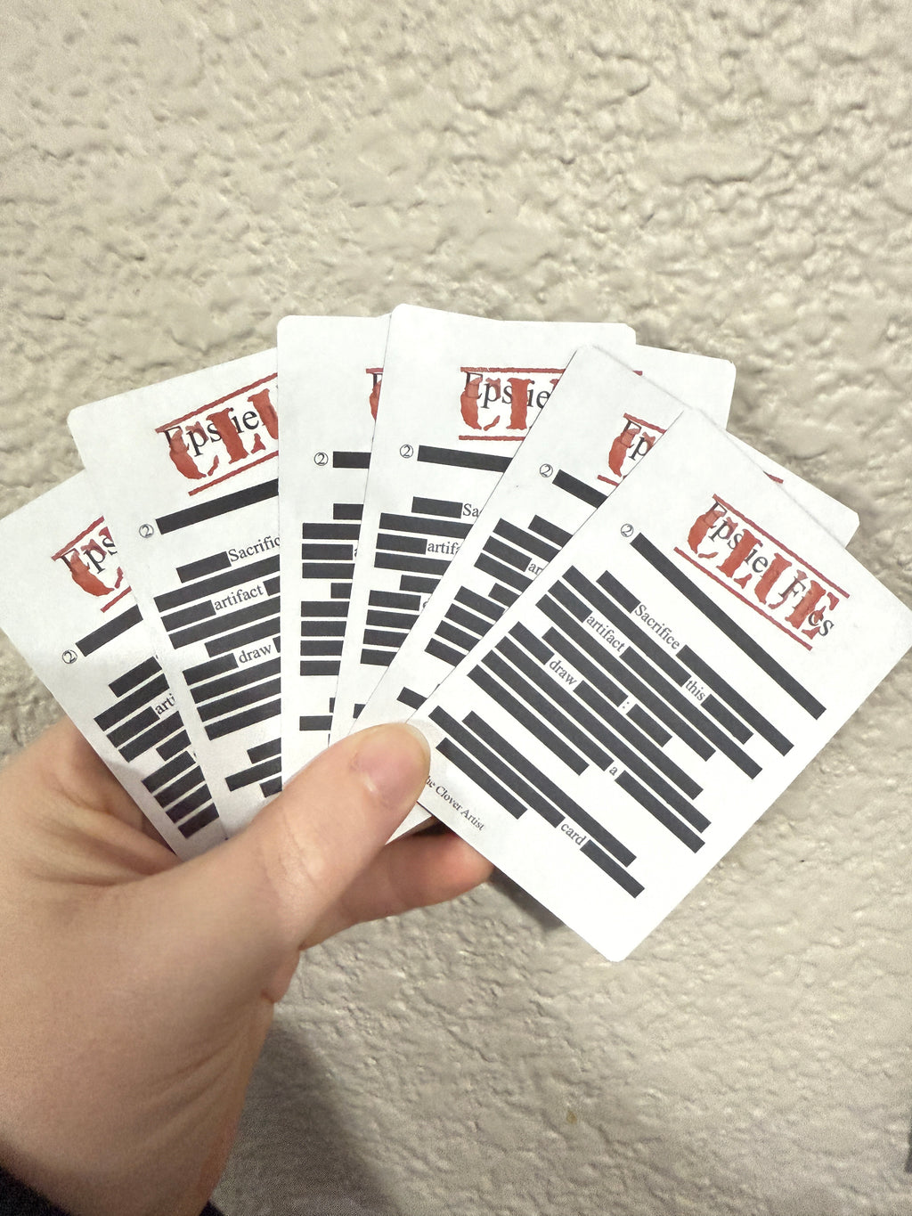 A stack of clue tokens that look like the redacted files from the Epstein files