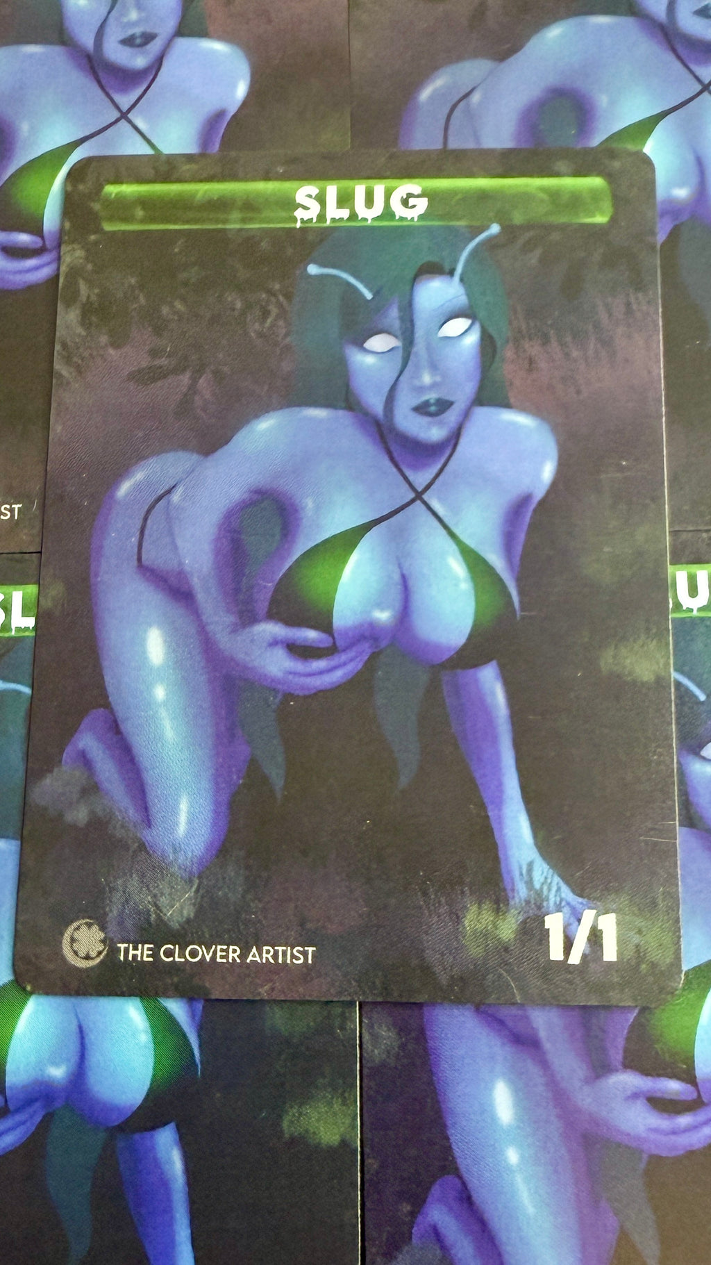 Card featuring a stylized character with 'SLUG' text and 'The Clover Artist' branding.