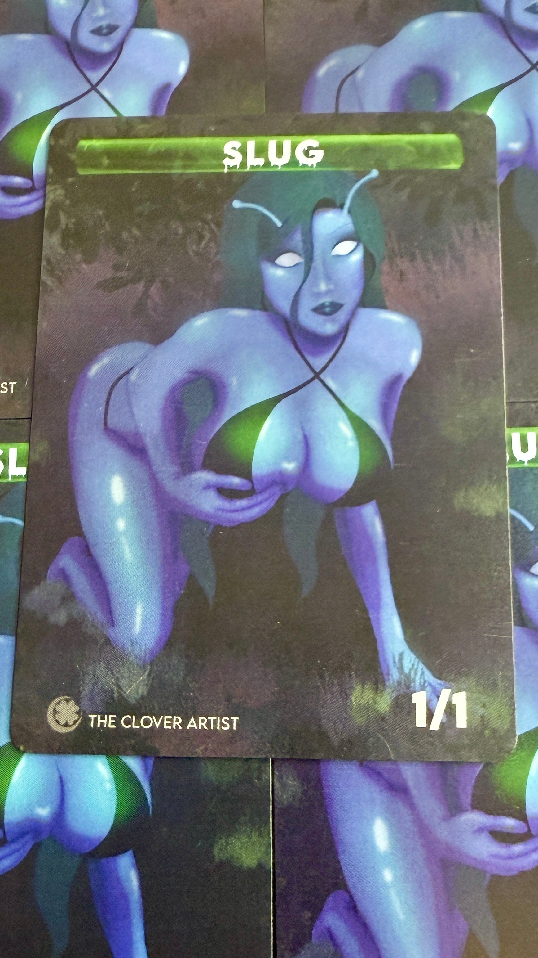 Card featuring a stylized character with 'SLUG' text and 'The Clover Artist' branding.